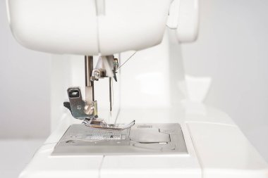 Modern beyaz dikiş makinesi presör ayak yakın çekim, makro. Dikiş ekipmanları, atölye işi, imalat, meslek için çalışma aracı.