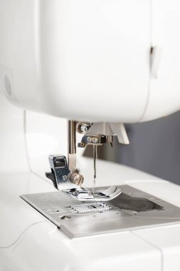Modern beyaz dikiş makinesi presör ayak yakın çekim, makro. Dikiş ekipmanları, atölye işi, imalat, meslek için çalışma aracı.