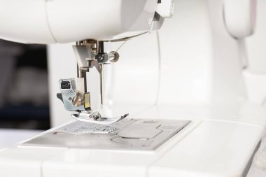 Modern beyaz dikiş makinesi presör ayak yakın çekim, makro. Dikiş ekipmanları, atölye işi, imalat, meslek için çalışma aracı.
