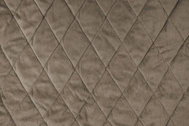 Örtülü kadife kumaş arka plan. Kahverengi desenli battaniye veya kabarık ceket, elmas desenli, yumuşak buruşuk yüzey, çatlamış tekstil