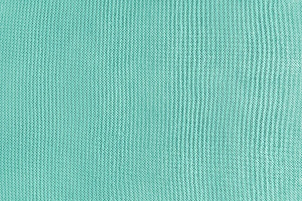 Texture background of turquoise velours fabric. Textile structure, cloth surface, weaving of jacquard material closeup. Upholstery, curtains, backdrop, wallpaper.