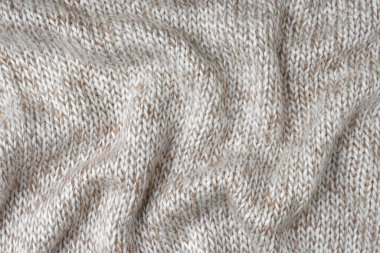 Bej ve beyaz renkli melanj kaşmir yün kumaş dokusu örüyor. Buruşuk, buruşuk örgü kumaş, tekstil yapı, kumaş yüzey, örgü kumaş dokuma.