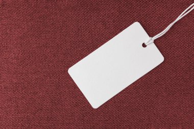 Tekstil arka planı, beyaz boş giyim etiketli kırmızı kabarık kumaş döşeme, mobilya tekstil malzemesi, fon, maket. Kumaş yapısı kapat.