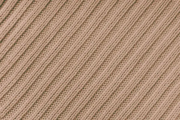 Jersey textile background , beige diagonal striped knitted fabric. Woolen knitwear, sweater, pullover surface texture, textile structure, cloth surface, weaving of knitwear material