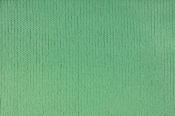 Green knitted woolen jersey fabric, sweater, pullover texture background. Fabric abstract backdrop, cloth wallpaper