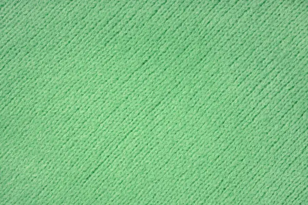 Green knitted woolen jersey fabric with diagonal weaving, sweater, pullover texture background. Fabric abstract backdrop, cloth wallpaper