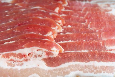 Çiğ domuz pastırması dokusu yakın plan. Çizgili et dilimleri, taze ince dilimlenmiş pastırma eti, yemek malzemesi.