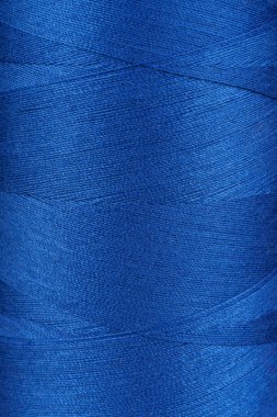 Makaradaki mavi renk ipliklerinin dokusu yakın, makro. İplikler dikiliyor bobbin soyut arkaplan, duvar kağıdı, arkaplan.