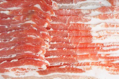Çiğ domuz pastırması dokusu yakın plan. Çizgili et dilimleri, taze ince dilimlenmiş pastırma eti, yemek malzemesi.