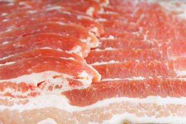 Çiğ domuz pastırması dokusu yakın plan. Çizgili et dilimleri, taze ince dilimlenmiş pastırma eti, yemek malzemesi.