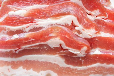 Çiğ domuz pastırması dokusu yakın plan. Çizgili et dilimleri, taze ince dilimlenmiş pastırma eti, yemek malzemesi.