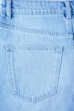 Kot pantolonun arka cebi yakın plan. Denim arka plan, doku, model. Moda konsepti, alışveriş, satış. Tasarım ayrıntısı, giysi ögesi