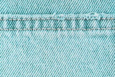 Turkuaz kot pantolon kumaşlı, dikişli, yakın çekim, makro. Kumaş dokusu duvar kağıdı, arkaplan, tasarım ayrıntıları.
