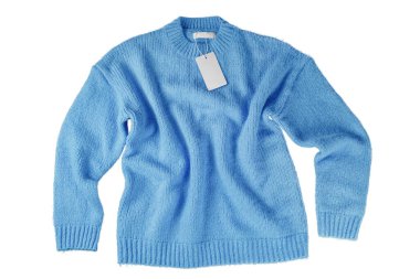 Mavi uçan sonbahar örgü süveteri ve beyaz arka planda boş etiket etiketi. Yaratıcı kıyafet konsepti, kışlık rahat, gıcırtılı kazak. Moda şablonu, model