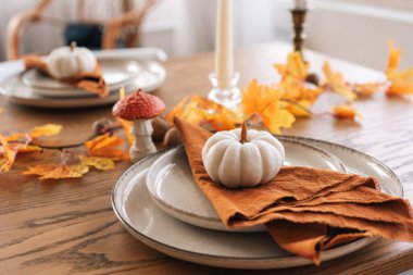 Sonbahar, sonbahar, Cadılar Bayramı ya da Şükran Günü şenlik masası. Tahta arka planda düşmüş yapraklar, balkabakları ve peçeteler..