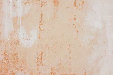 Textured plaster wall surface with peeling paint in various shades of orange and white color. Aged, weathered background. Wallpaper, backdrop, design element clipart