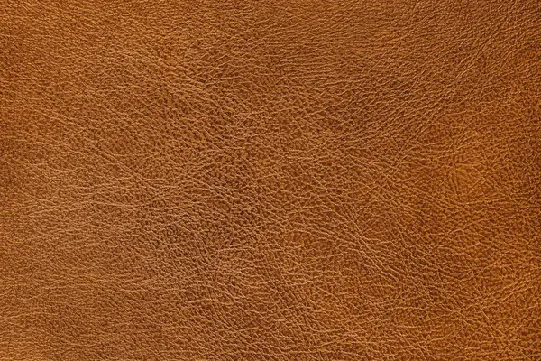 Gerçek deri yüzey yapısı ve hafif kumlu doku makrosu, yakın çekim. Pürüzsüz parlak turuncu deri, döşeme malzemesi, lüks arka plan, arka plan, duvar kağıdı.