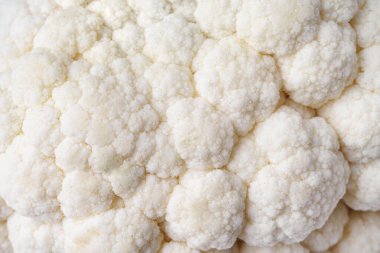 Organik taze olgun beyaz karnabahar desenli makro, yakın çekim. Yemek arkaplanı dokusu, sebze duvar kağıdı, fon. Sağlıklı, diyet, çiğ yemek malzemesi..