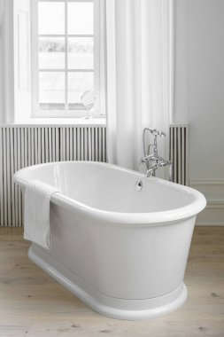 Perdeleri, penceresi ve serbest küveti olan modern minimalist banyo. Ev tasarımı, rahat atmosferli ev tasarımı.