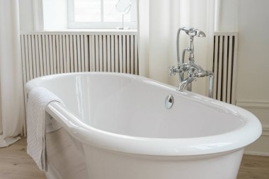 Perdeleri, penceresi ve serbest küveti olan modern minimalist banyo. Ev tasarımı, rahat atmosferli ev tasarımı.