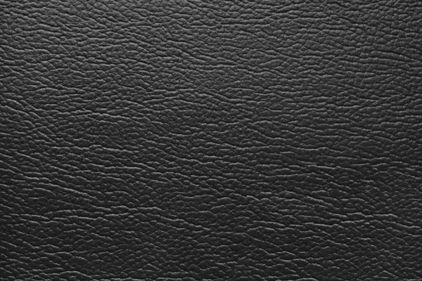 Gerçek deriden parlak bir yapı, kabartma desenli doğal bir deri. Sanatsal siyah leatharette yakın çekim, makro doku. Arkaplan, duvar kağıdı, arkaplan.