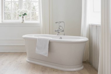 Perdeleri, penceresi ve serbest küveti olan modern minimalist banyo. Ev tasarımı, rahat atmosferli ev tasarımı.