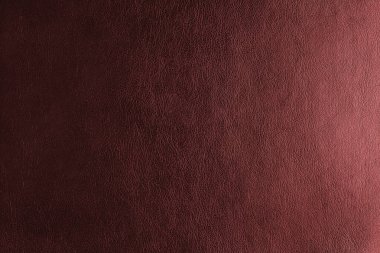 Işıklandırma etkisi olan parlak deri yapısı, kabartma desenli doğal deri yüzeyi. Sanatsal kırmızı renkli leatharette makro doku. Arkaplan, duvar kağıdı, arkaplan.
