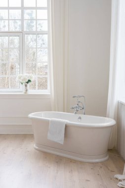 Perdeleri, penceresi ve serbest küveti olan modern minimalist banyo. Ev tasarımı, rahat atmosferli ev tasarımı.