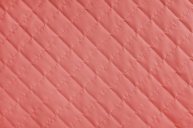 Damalı, elmas dikişli, kırmızı örtülü kumaş arka plan. Battaniye ya da kabarık ceket, dikiş eşkenar dokusu yakın, makro. Duvar kağıdı, arkaplan.