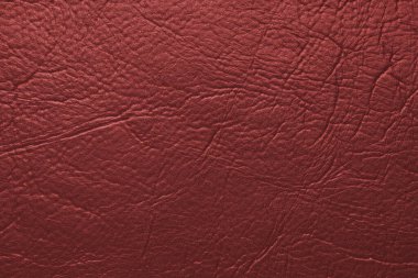 Yakın çekim, kırmızı parlak doğal deri, deri kaplama, kabartmalı desenli sanatsal deri yüzeyi. Arkaplan, duvar kağıdı, arkaplan