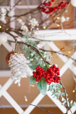 Noel süsü kırmızı böğürtlenler, yeşil yapraklar, parlak ışıklar ve çam kozalakları. Yeni yıl, kış tatili ev dekorasyonu. Duvar kağıdı, kopyalama alanı olan arkaplan