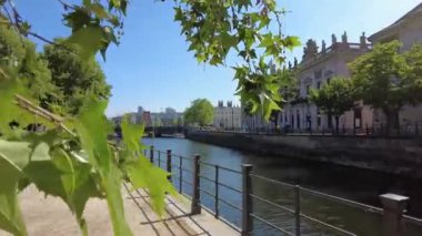 Berlin 'de Spree nehri boyunca yürü. Kamera nehir kenarındaki balüstrad 'dan nehrin yukarısına doğru hareket ediyor. Arka planda tarihi bir hükümet binası var.