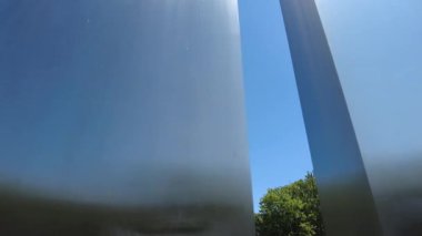 Berlin televizyon kulesi, sanatsal bir eser oluşturan iki yapının arasında mavi gökyüzünde beliriyor. Kamera sağa hareket ediyor.