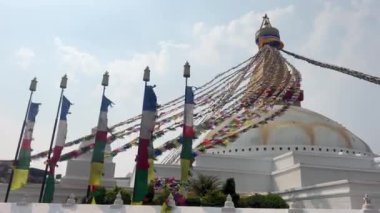 Katmandu 'daki en büyük Budist tapınağının kubbesi. Üzerine geleneksel dualar kazınmış pek çok renkli bayrak sallanıyor.