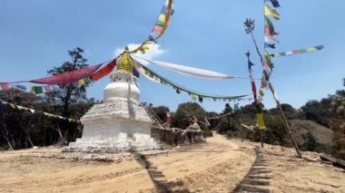 Doğada yürüyüş yolunda bir Budist sersemliği var. Altın kubbeli küçük tapınak, üstünde Buda 'nın gözleri ve sallanan geleneksel renkli bayraklar.