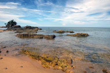 Pantai Kuala Kemasik ile Rocky Shoreline, Terengganu, Malezya 'nın sakin kıyı manzarası Terengganu, Malezya' daki Pantai Kuala Kemasik 'in doğal güzelliğini yansıtıyor..