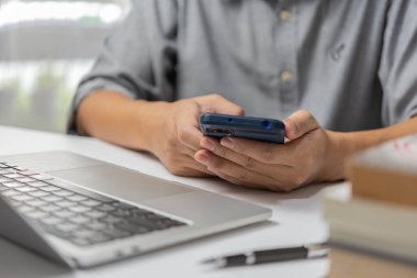 Adam elinde cep telefonu kullanıyordu. İş yerinde serbest çalışan. İnternette.