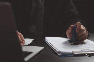 Çalışma finans bankacılığı ya da yatırım pazarlama belgelerini masanın üzerine damgalayan adam.