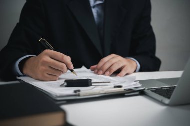 Car dealer businessman signing car insurance document. Car purchasing loan and insurance concept.