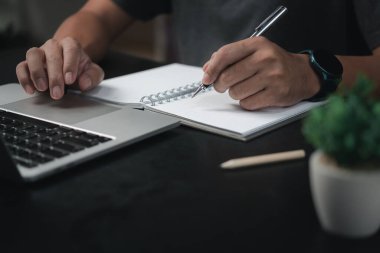 Ofisteki deftere kalem yazan erkek elleri. Öğrenme, eğitim ve çalışma. Hedefler, planlar, yapılacaklar ve dilekler listesi..