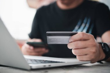 İş adamı internet bankacılığı için kredi kartı ve dizüstü bilgisayar kullanıyor. İnternet üzerinden alışveriş, e-ticaret, internet bankacılığı ve e-banka uygulaması konsepti üzerinden yapılan ödemeler.