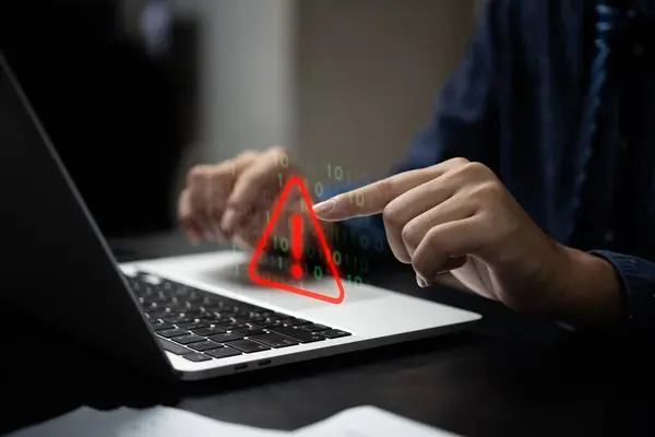 stock image Businessman programmer, developer using laptop computer with triangle caution warning sign for notification error and maintenance concept.