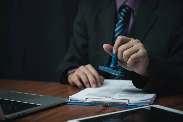 stock image Man hand stamping approval signing on document or paperwork contract at desk.