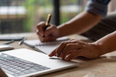 Eller bir tuş tahtasına basıyor. İş adamı yeni bir proje üzerinde çalışıyor. Not defteri, iş araması, internet üzerinden arama, online alışveriş..