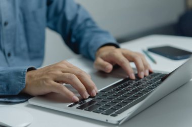 Klavye dizüstü bilgisayarında yazan, bilgi arayan ya da serbest çalışan bir adam. Dijital teknoloji çevrimiçi ağ ve sosyal medya kavramı.