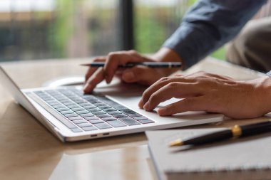 Eller bir tuş tahtasına basıyor. İş adamı yeni bir proje üzerinde çalışıyor. Not defteri, iş araması, internet üzerinden arama, online alışveriş..