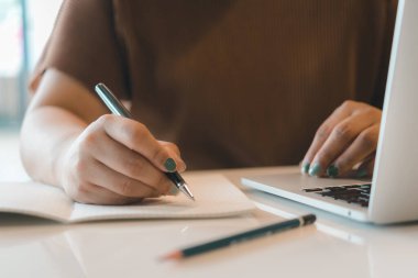 El kadını çalışma alanını bilgisayar kullanarak not alıyor. İletişim ve bilgi yönetimi. eğitim, iş veya yaratıcı iş konsepti.