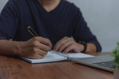 Çalışma masasında çalışan işadamı, kalem ve kağıt kullanarak yazma ve planlama için not alır. konseptler iş organizasyonu, veya yönetim, strateji, iletişim.