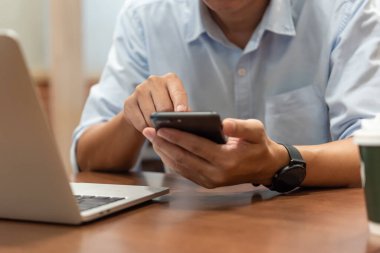 Bağlı kalmak için dokunmatik ekranlı akıllı telefonu kullanan, interneti gezen, bilgiye erişen ve sosyal medyaya bağlanan adam.