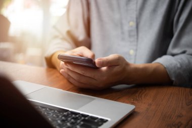 Dizüstü bilgisayarda çalışan ve cep telefonu iletişimi ve sosyal medya interneti kullanan iş adamı, Bilgi ve iş başvurusu kavramını arıyor.